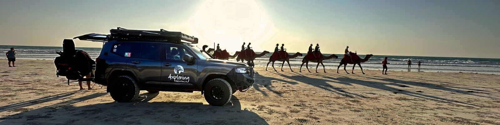 Broome rental vehicle parked on beach with camel safari tour